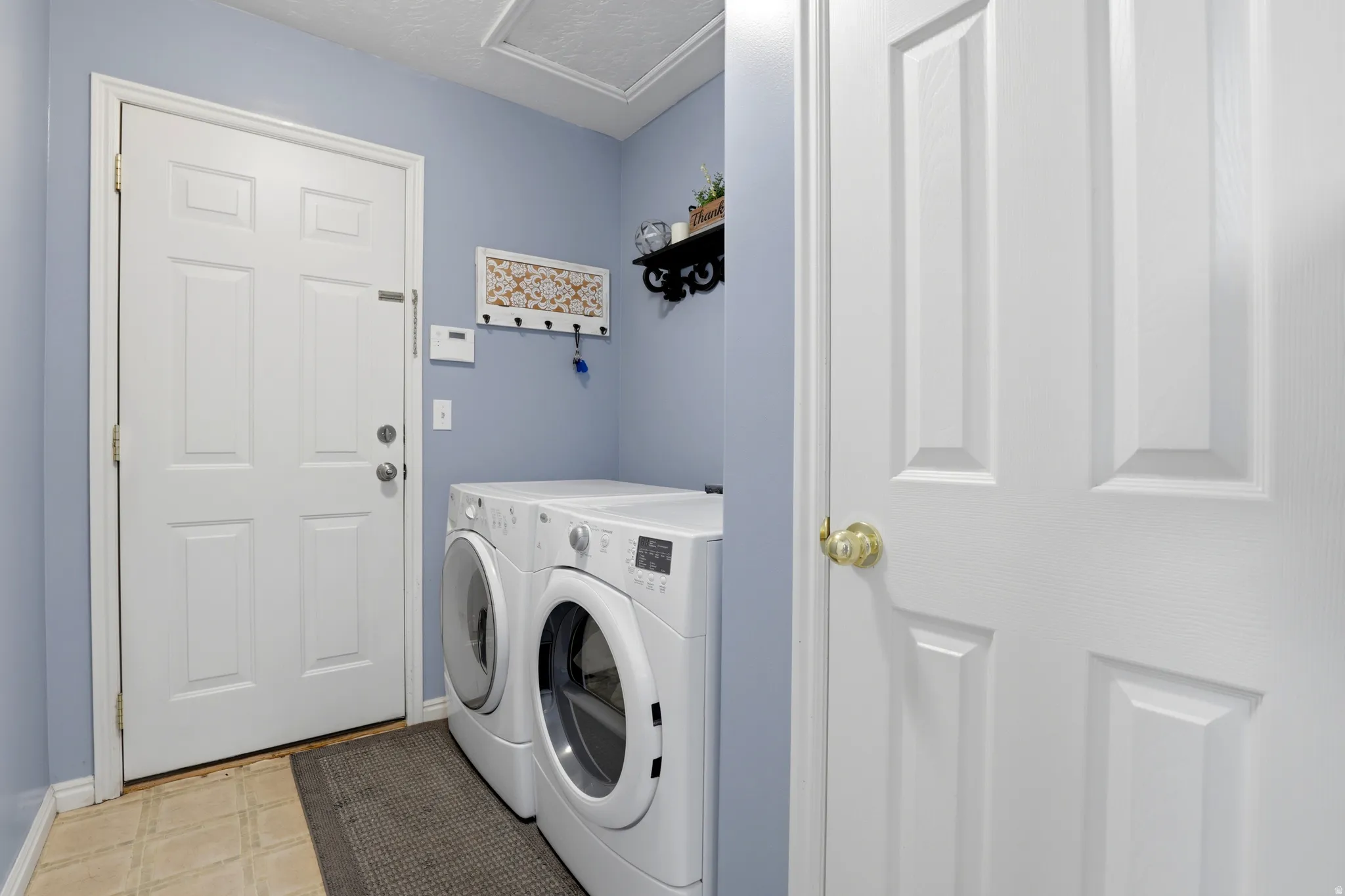 Laundry area with washing machine and clothes dryer and a textured ceiling