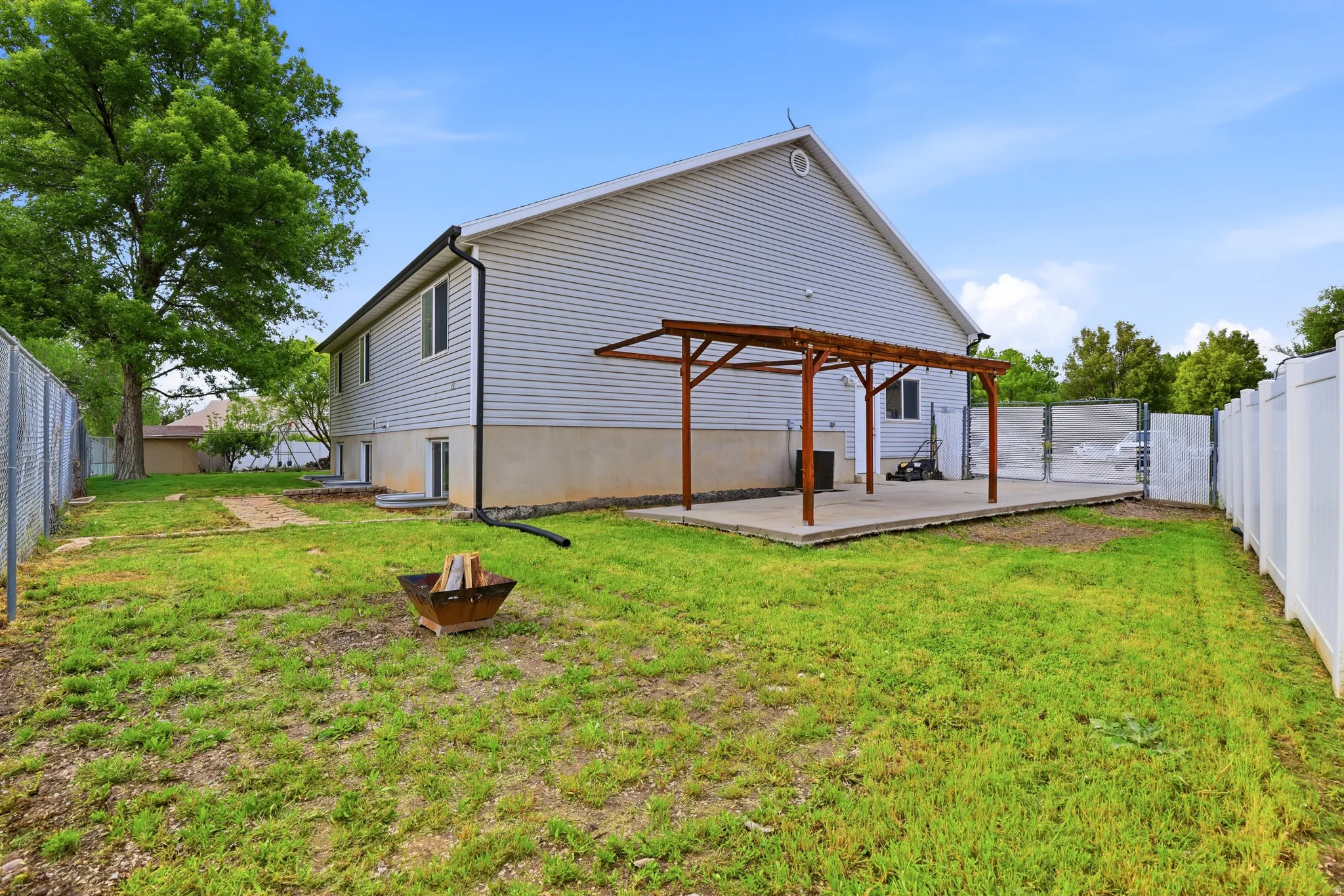 Rear view of house featuring a fenced backyard and a pergola