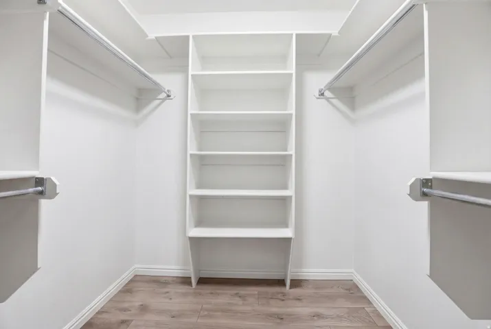 Walk in closet with light wood finished floors