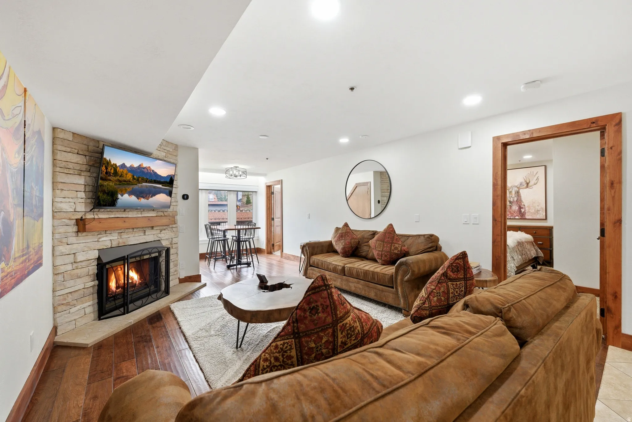 Living area featuring a stone fireplace, light wood-style flooring, and recessed lighting