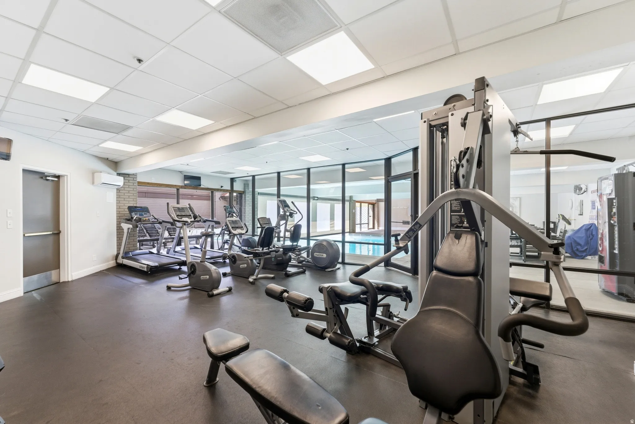 Exercise room featuring a paneled ceiling, a mini split for heating / cooling, and expansive windows