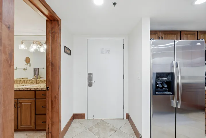 Doorway featuring tile patterned floors and baseboards