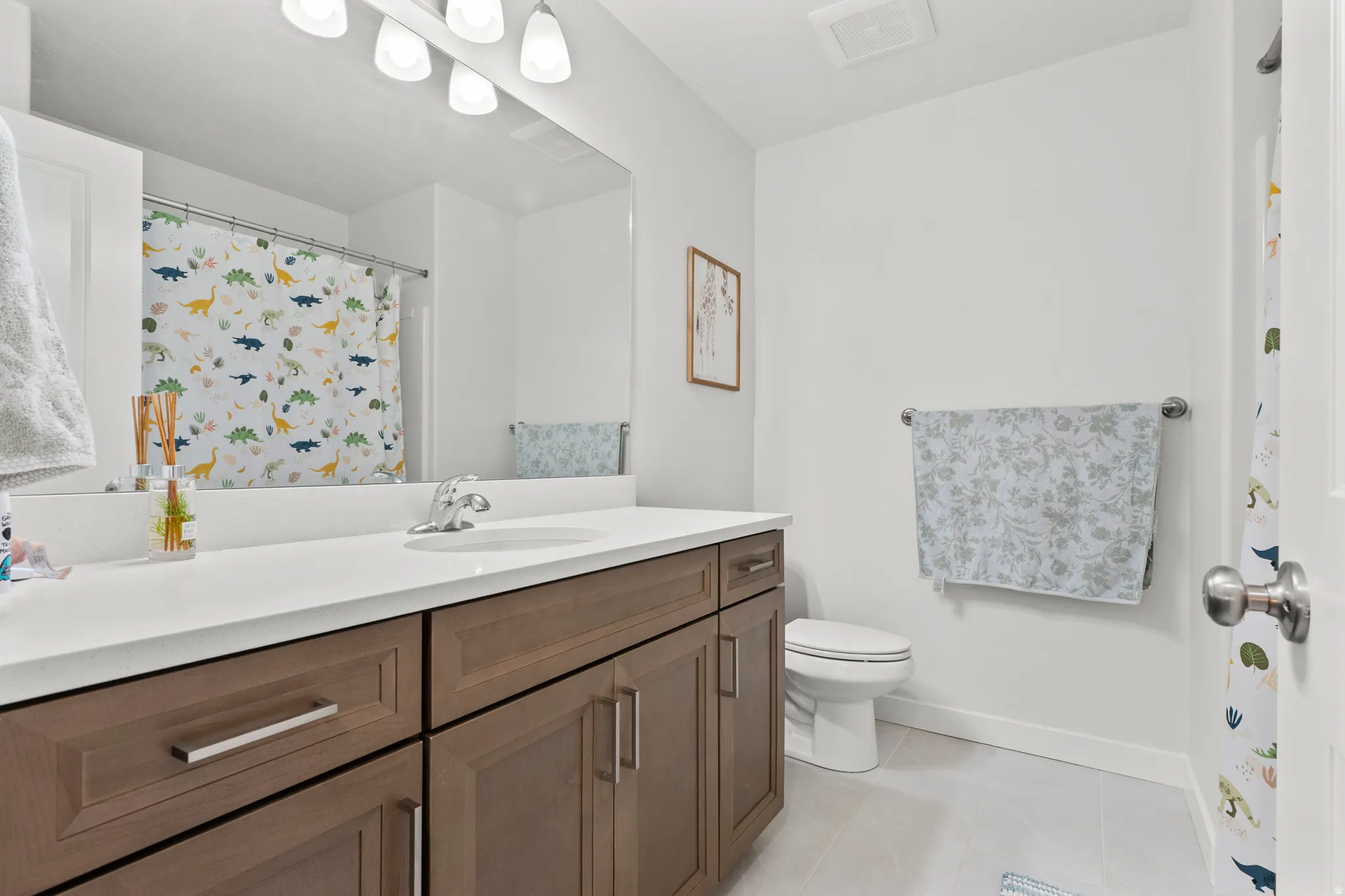 Full bathroom with vanity, a shower with shower curtain, and light tile patterned floors