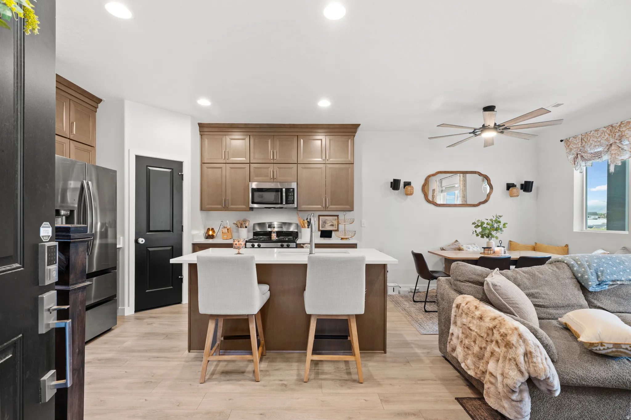 Kitchen with open floor plan, an island with sink, recessed lighting, light wood-style floors, and a kitchen bar