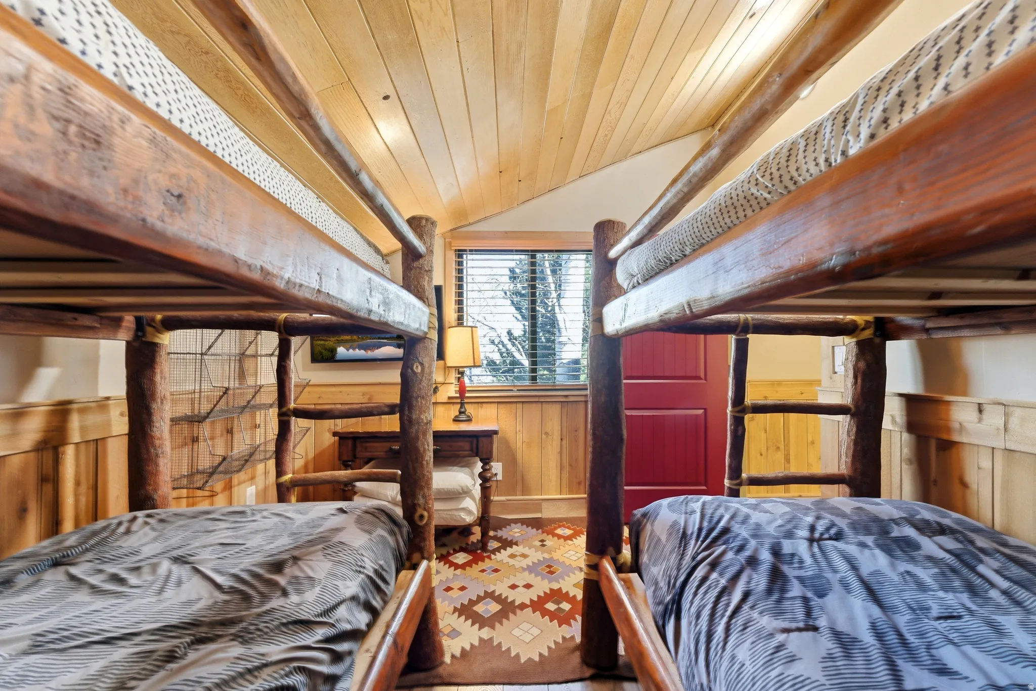 Bedroom with a vaulted wooden ceiling and wood walls