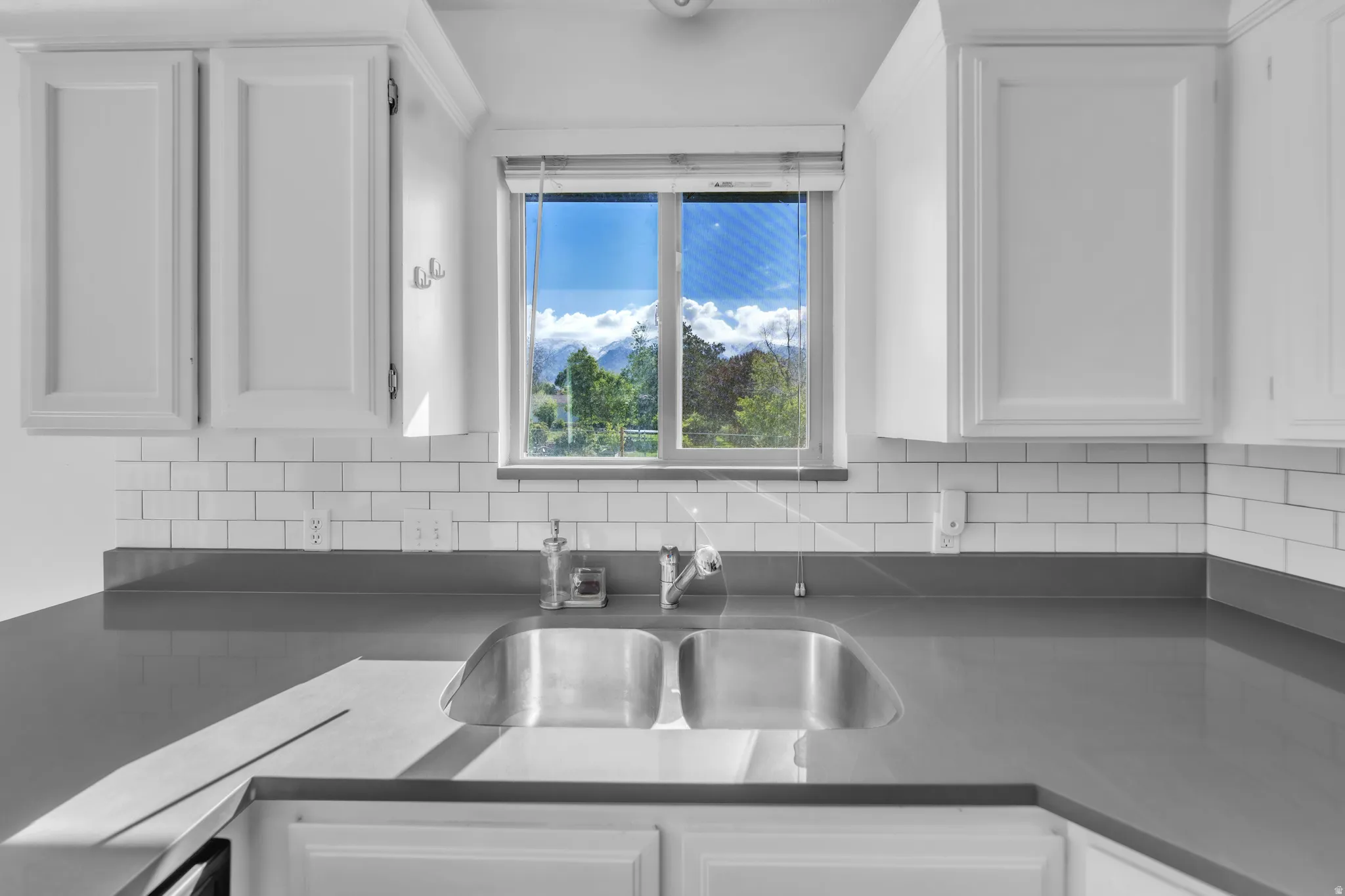 Kitchen featuring white cabinets and decorative backsplash
