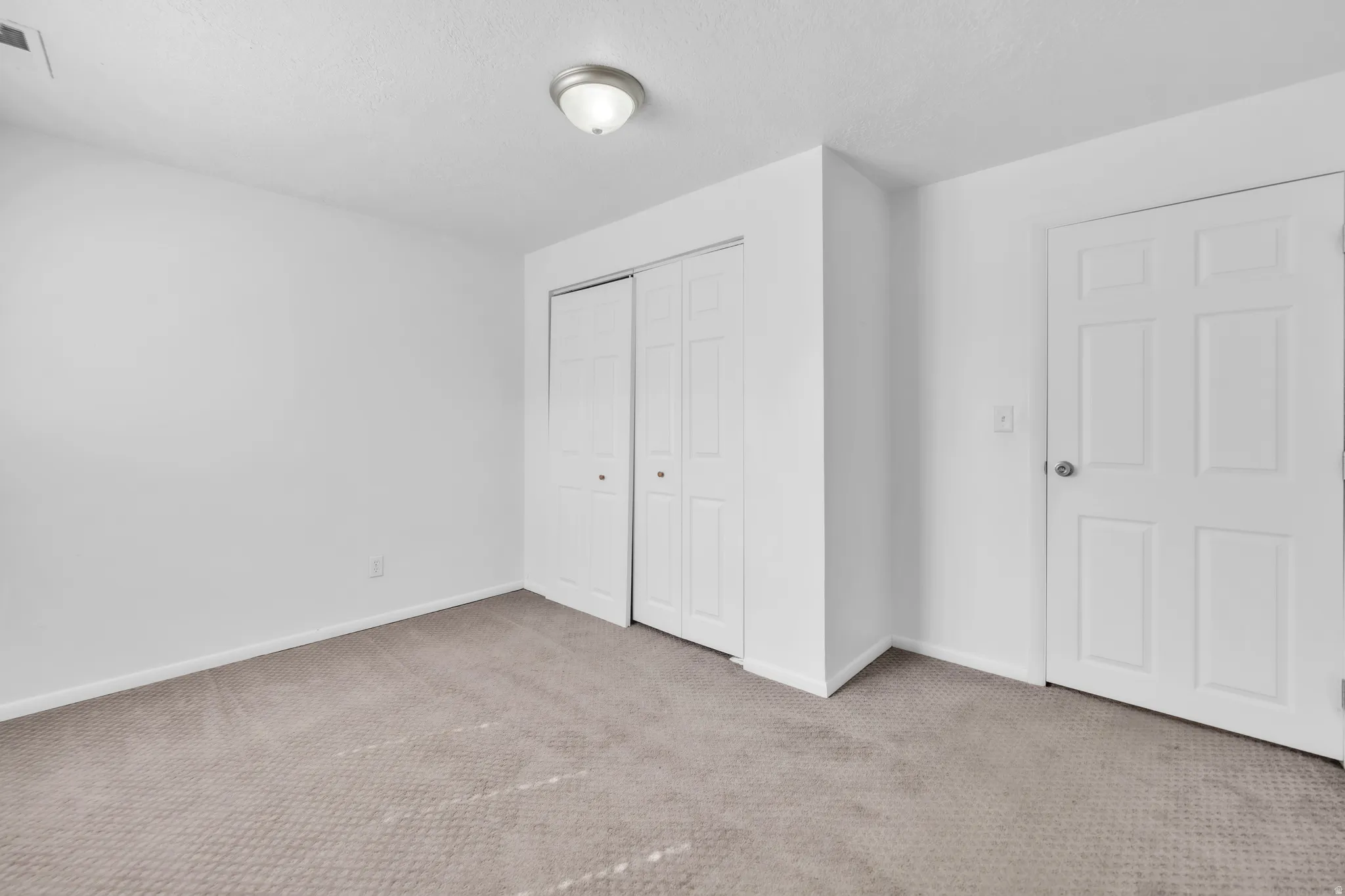 Unfurnished bedroom with carpet, a closet, and a textured ceiling