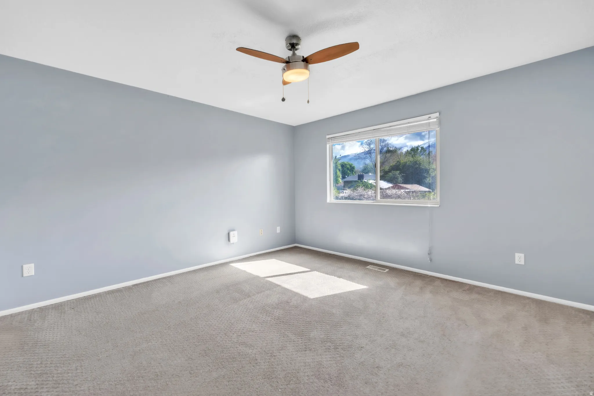 Unfurnished room with carpet floors and a ceiling fan