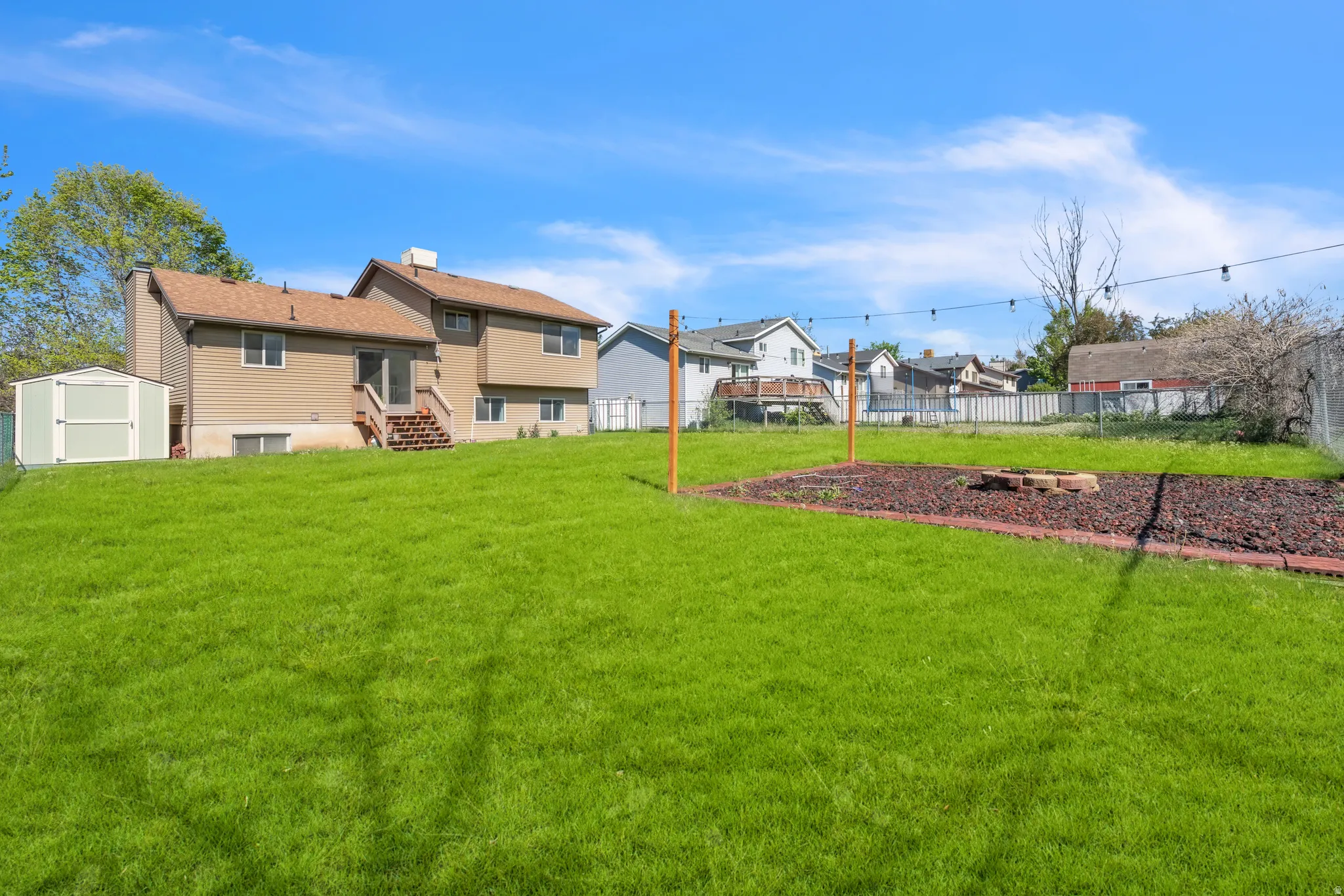 Fenced backyard with a storage shed and entry steps