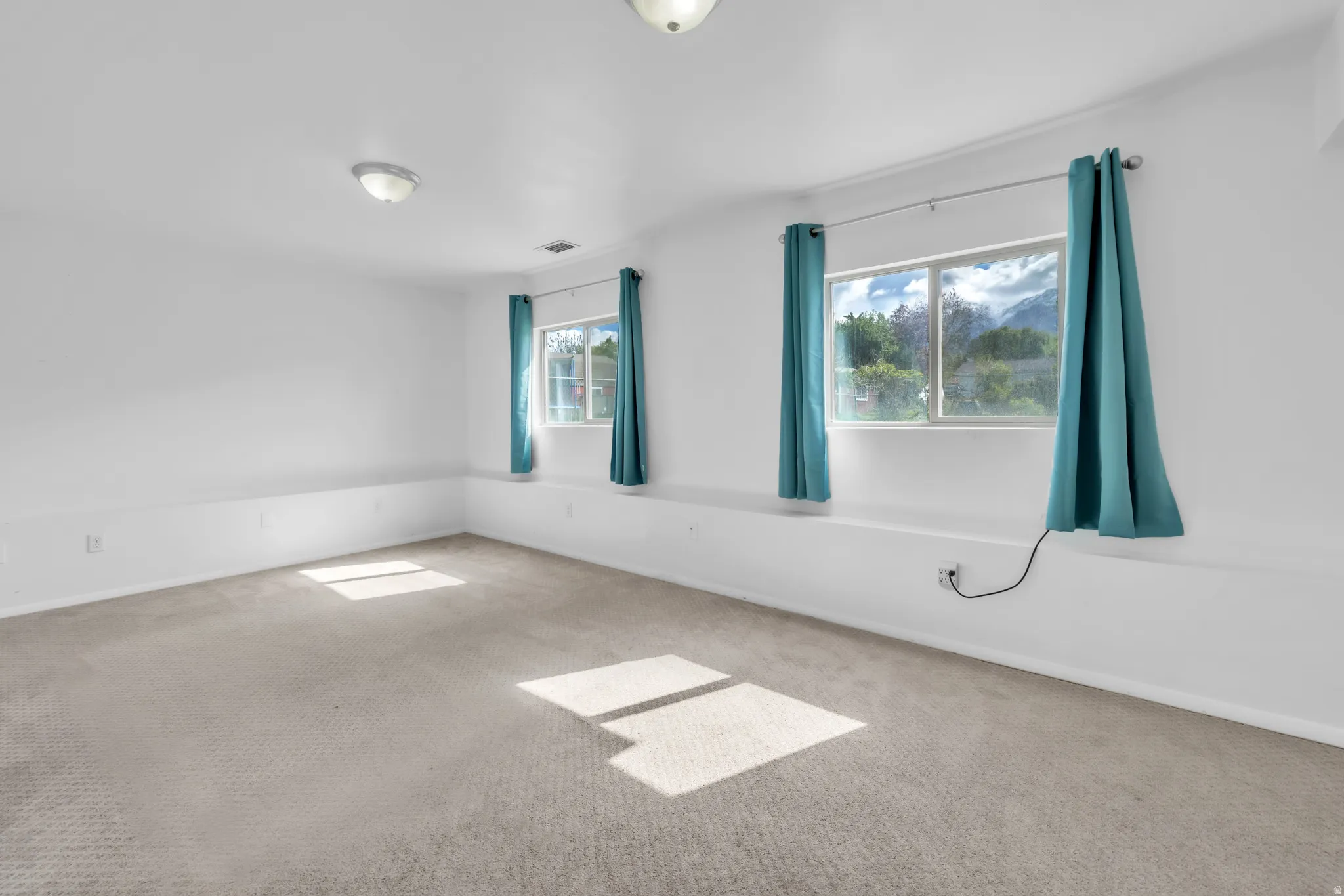 Carpeted empty room featuring baseboards