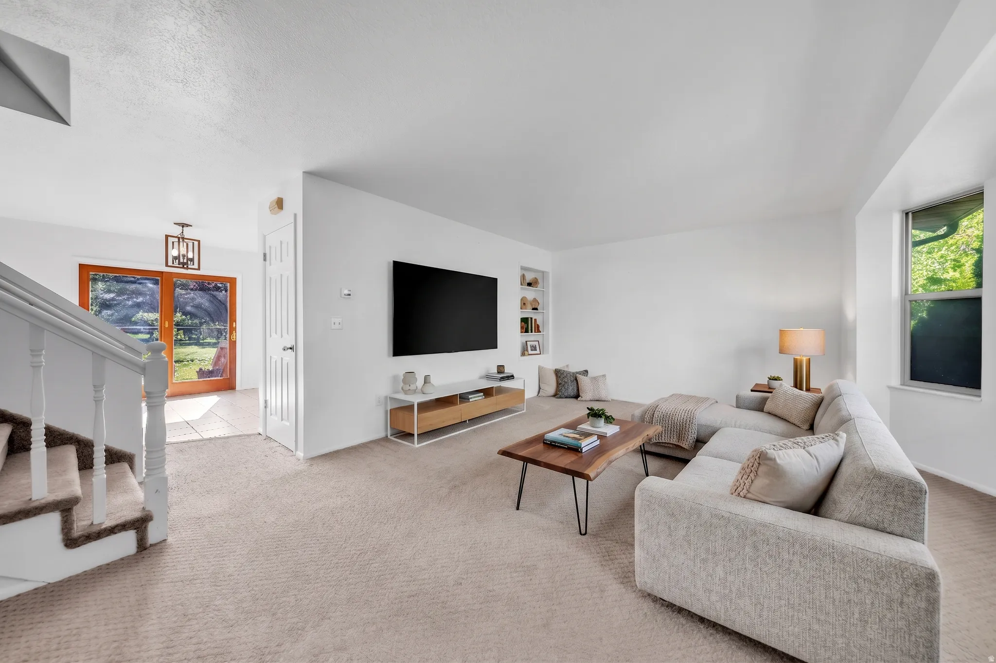 Living area featuring light carpet and built in shelves