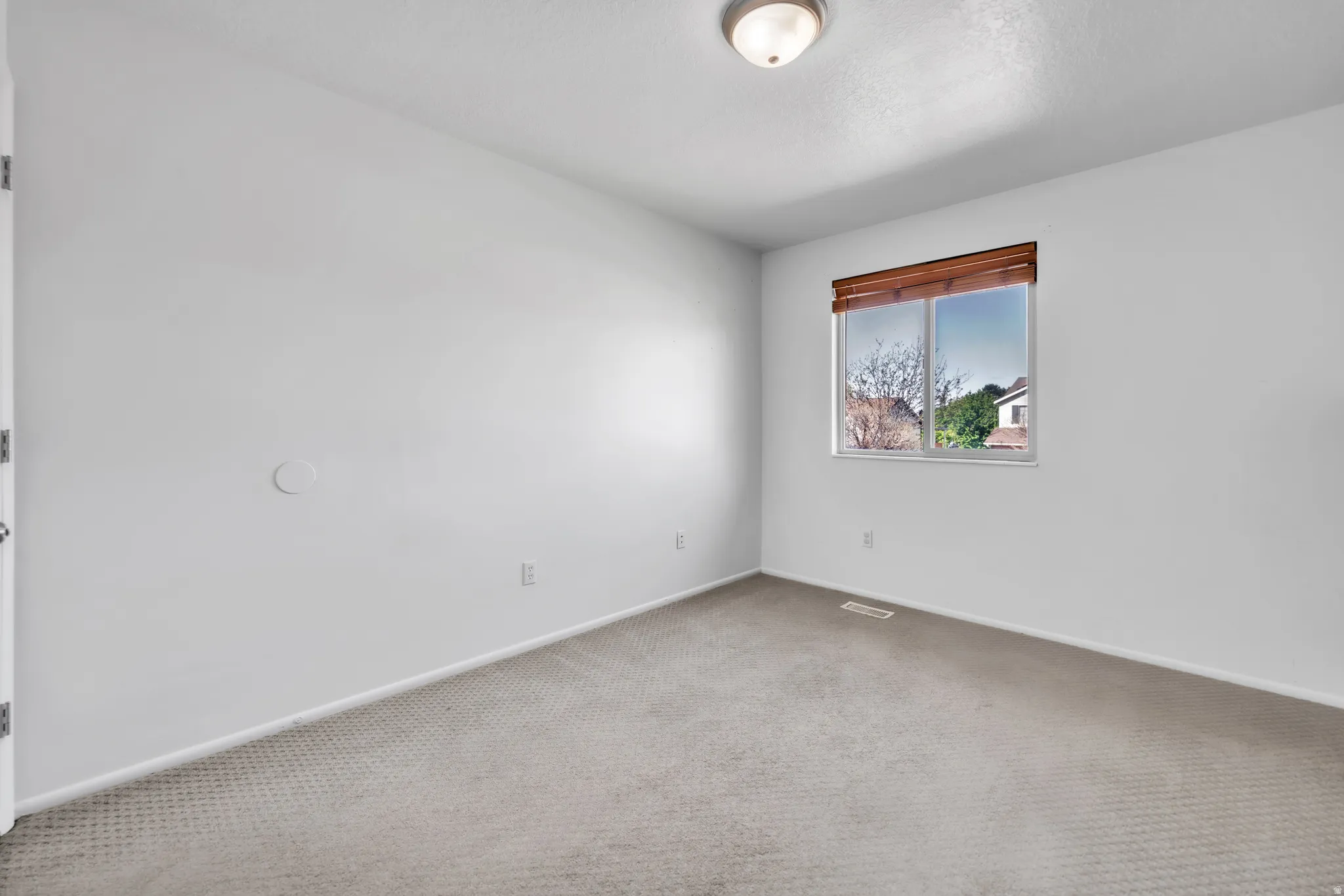 Carpeted empty room featuring baseboards