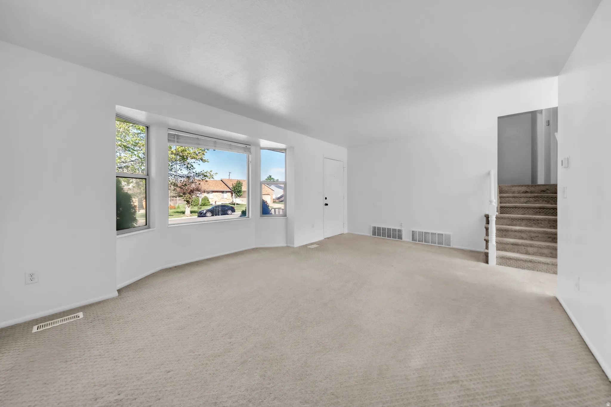 Spare room featuring carpet and stairs