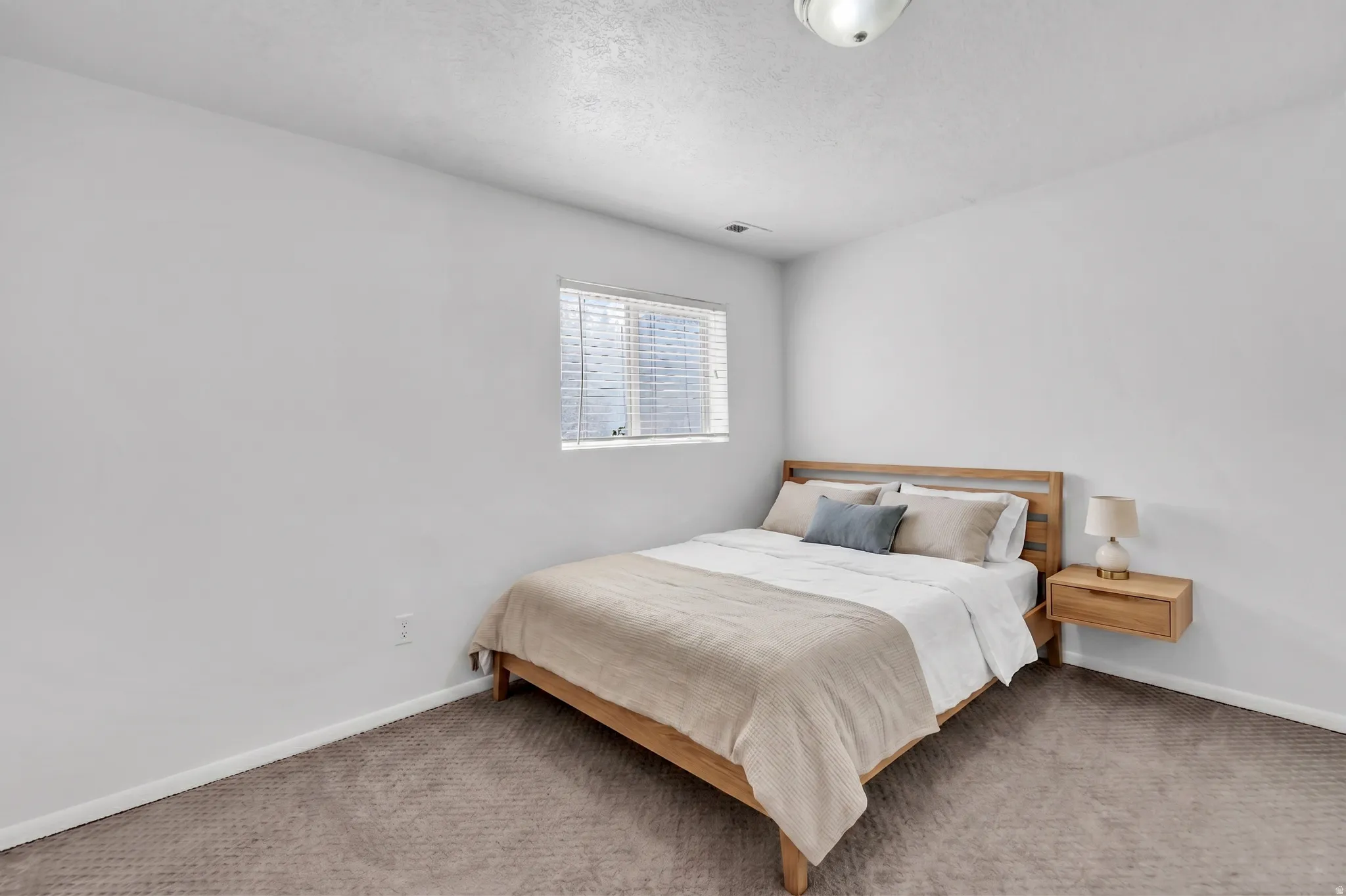 Bedroom with carpet and a textured ceiling