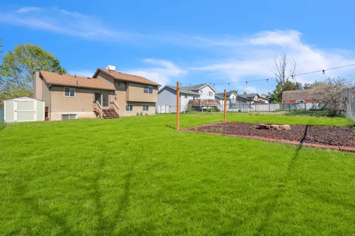 Fenced backyard with a storage shed and entry steps