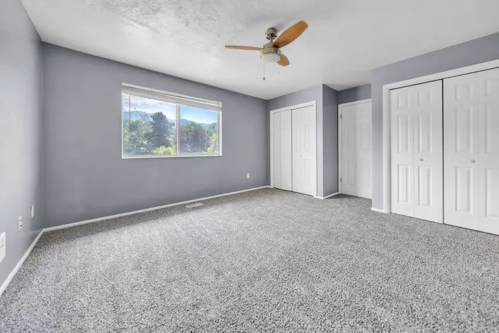 Spacious room with gray textured carpet and matching wall paint
