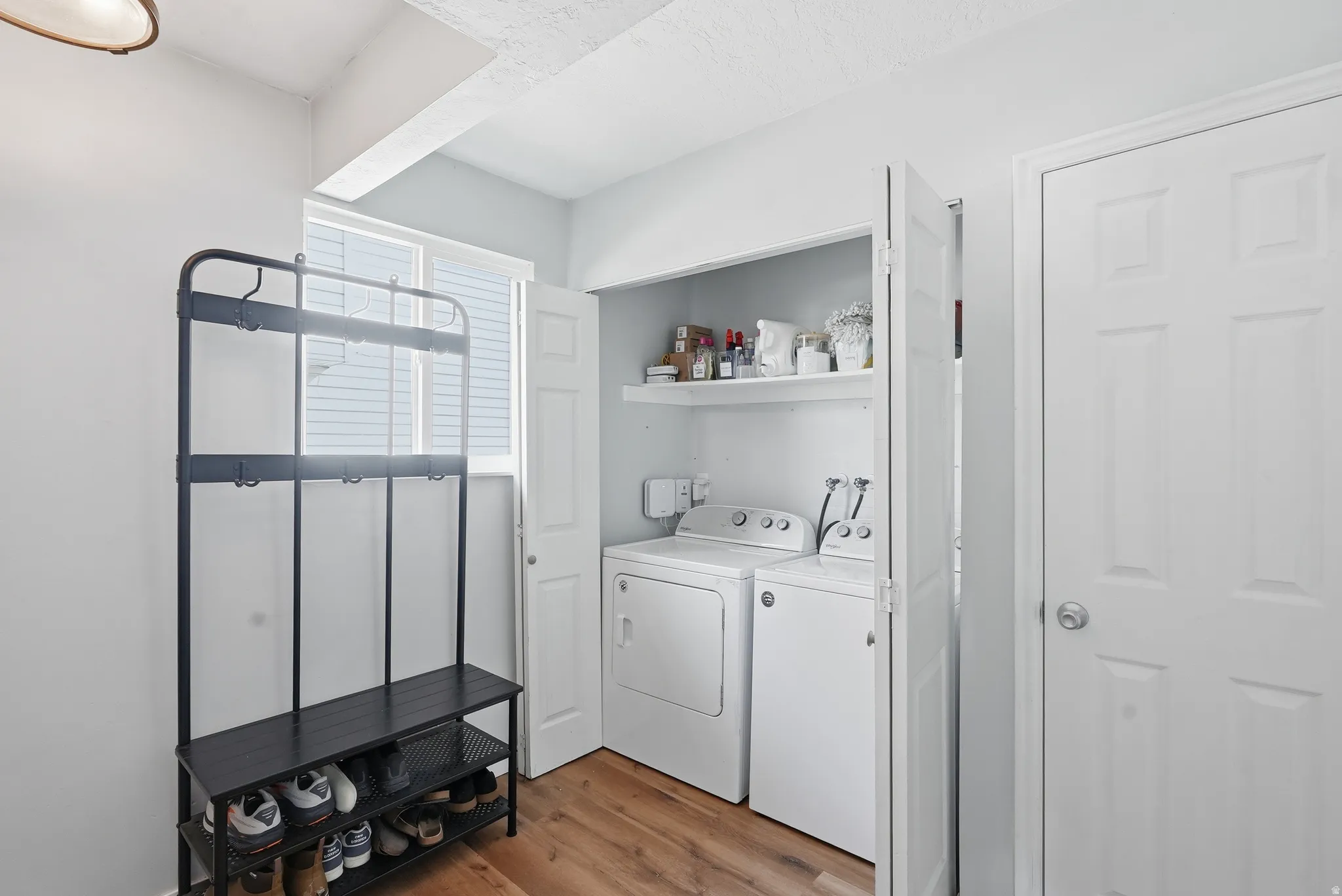 Laundry area featuring light wood-type flooring and independent washer and dryer