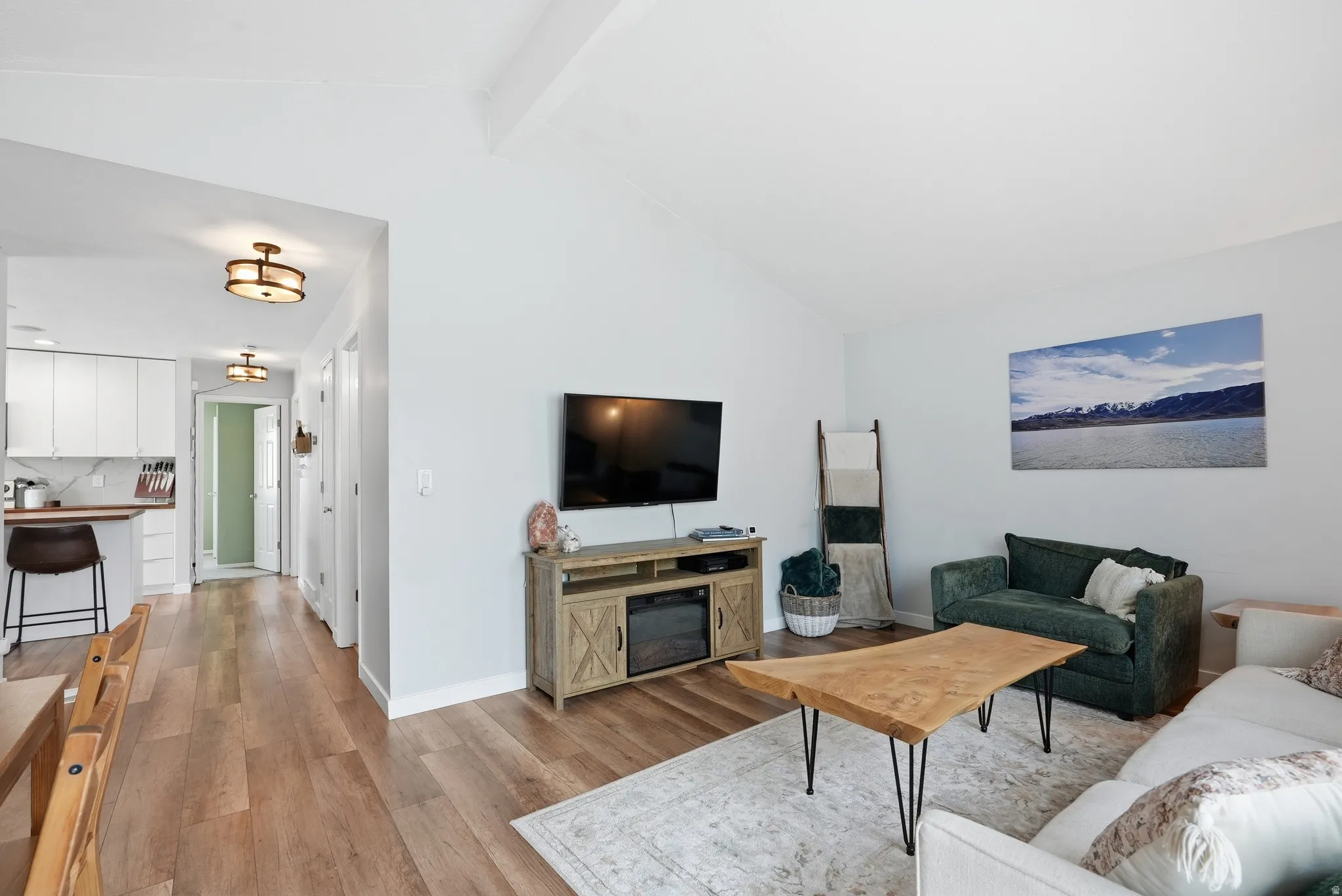 Living room featuring beam ceiling and light wood-style floors