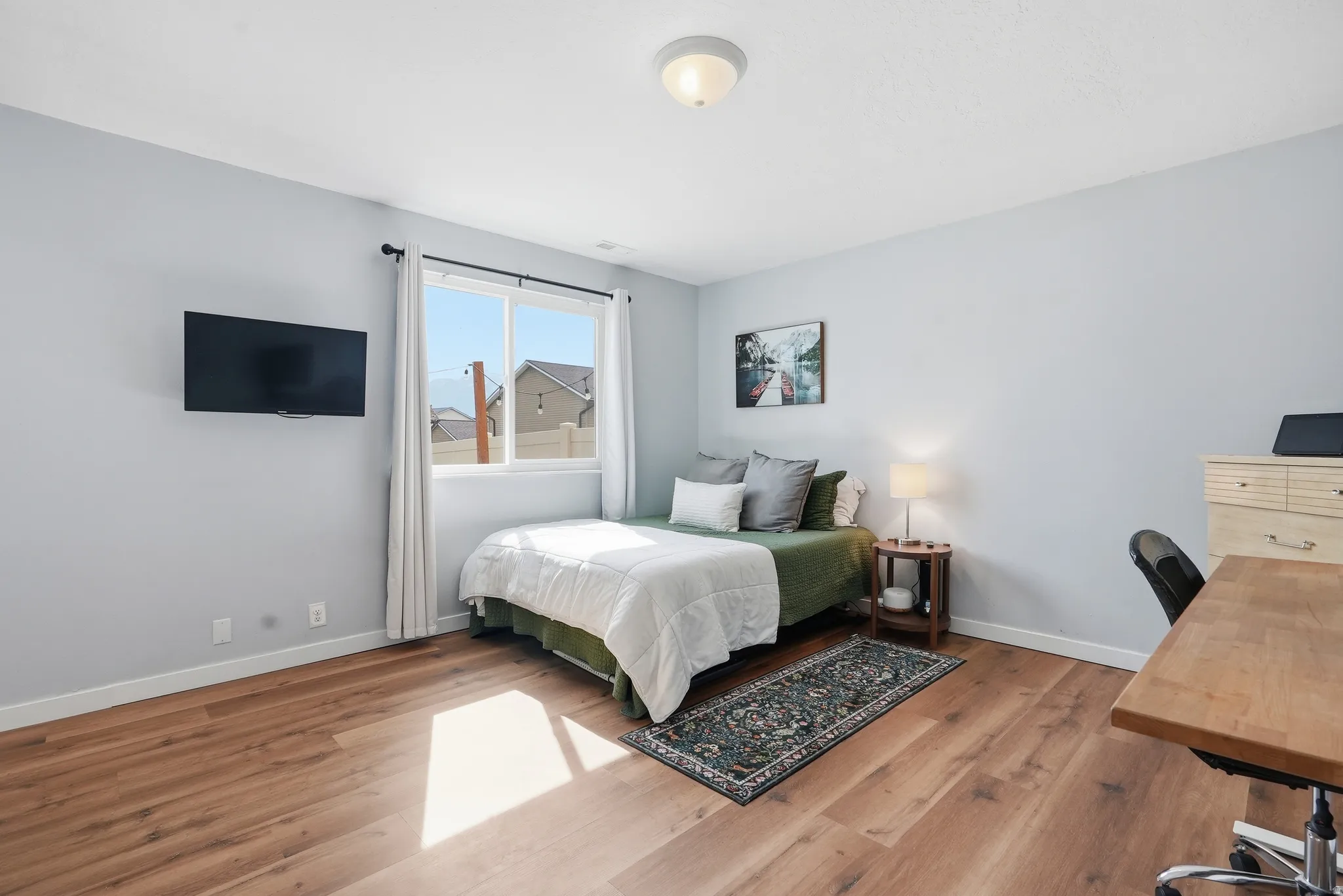 Bedroom featuring an office area and light wood-style flooring