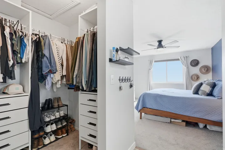 Bedroom with light colored carpet and attic access