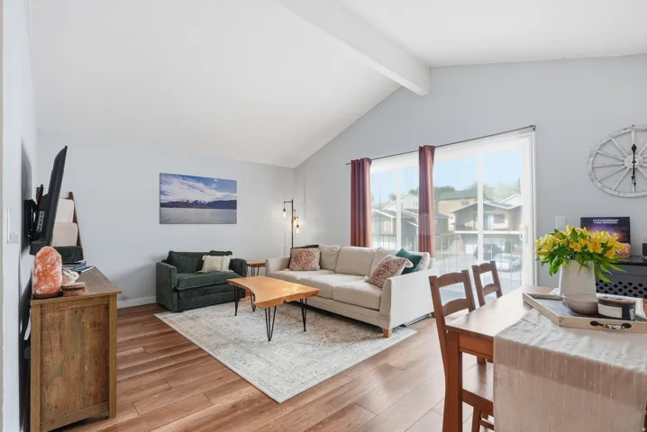 Living room featuring light wood-style floors and beam ceiling