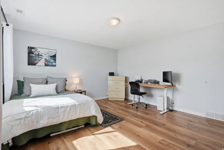 Bedroom with light wood-style floors and an office area