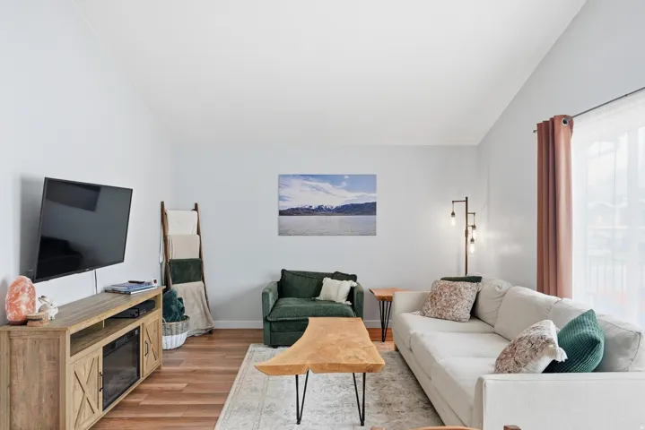 Living room with lofted ceiling and light wood-style flooring