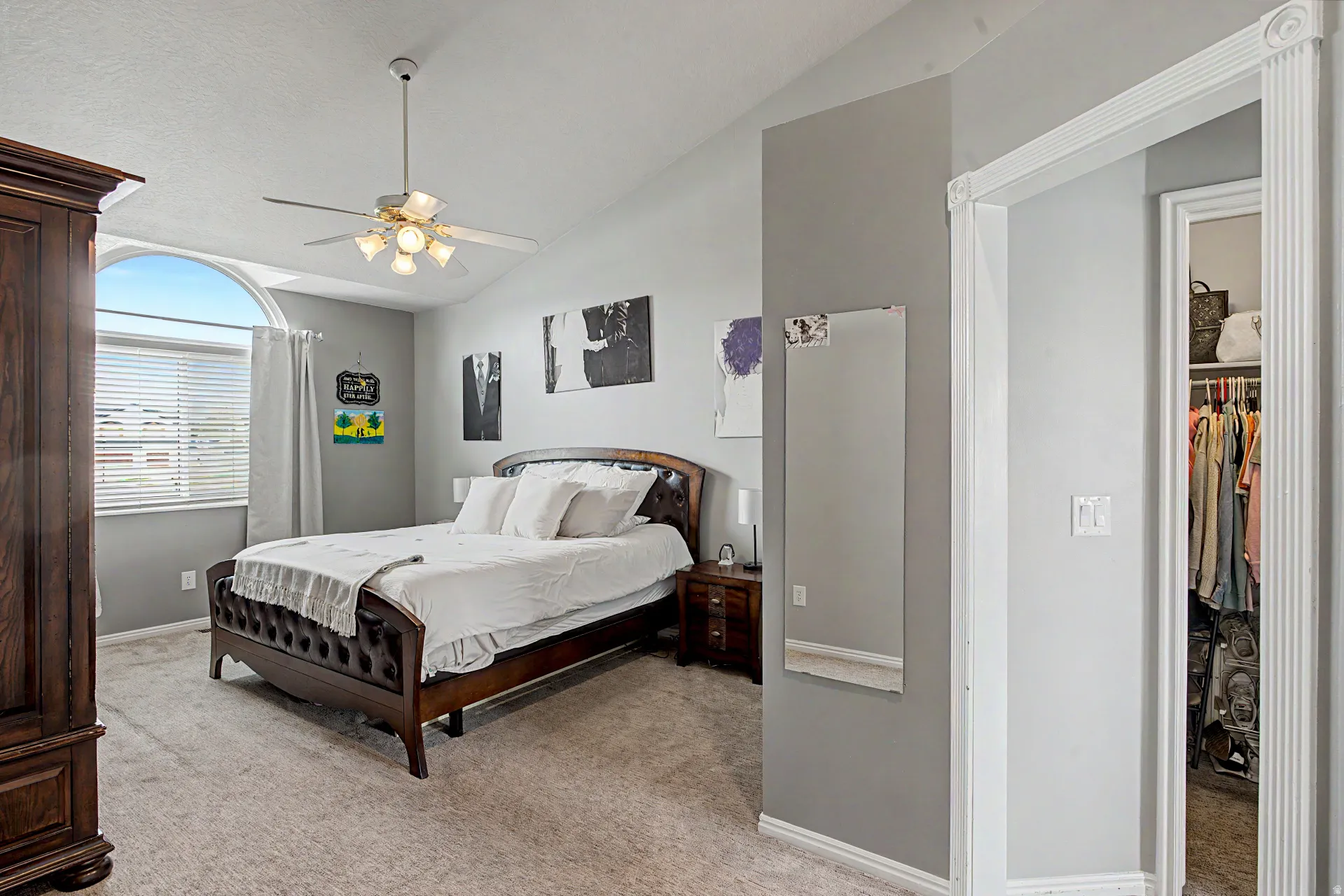 Bedroom featuring light colored carpet, vaulted ceiling, and ceiling fan