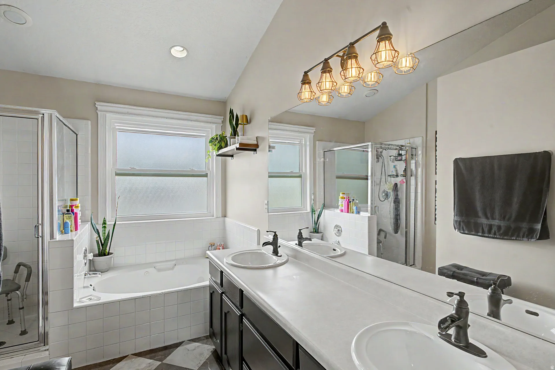 Full bathroom with double vanity, a garden tub, and a stall shower