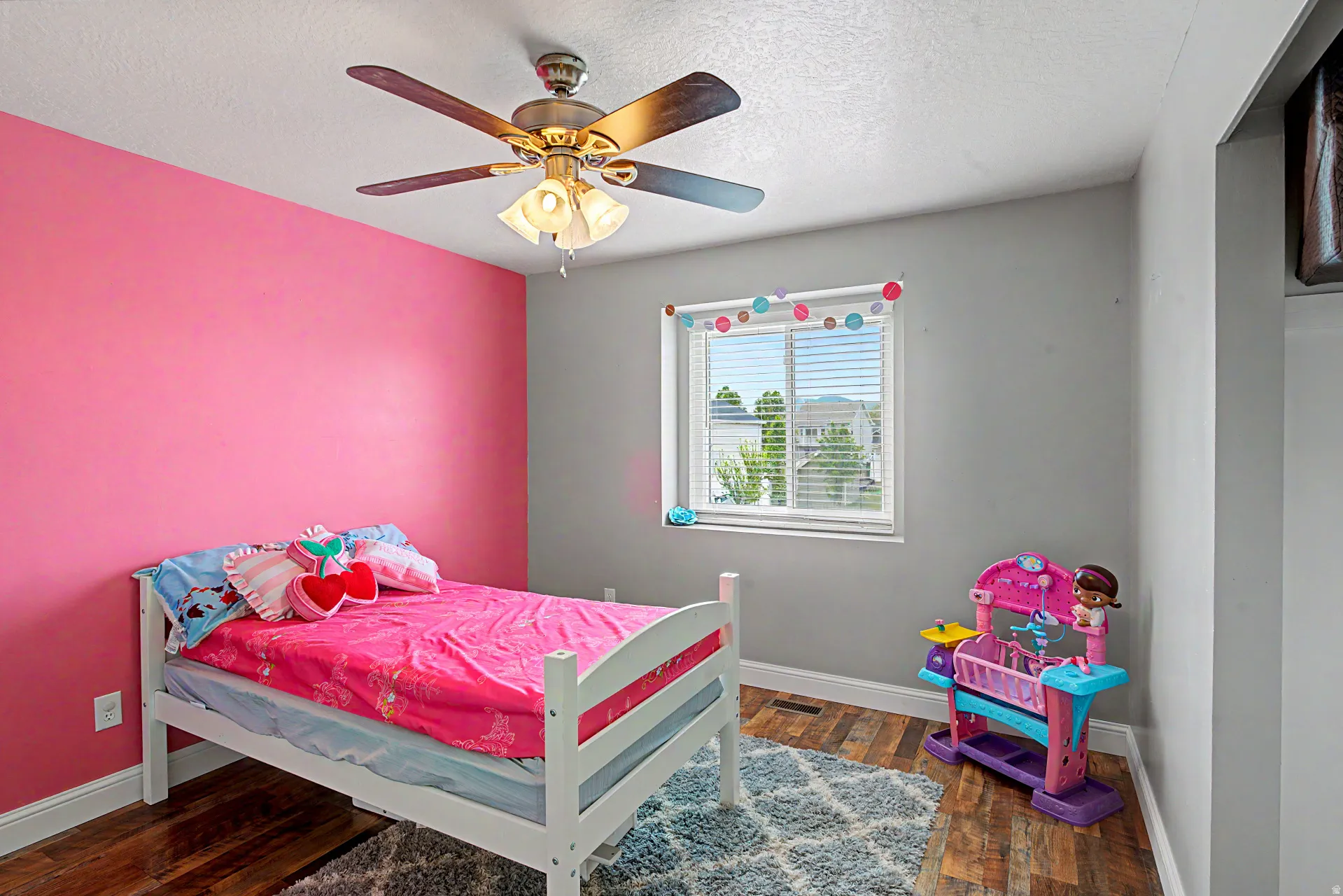 Bedroom with dark wood finished floors, a textured ceiling, and a ceiling fan