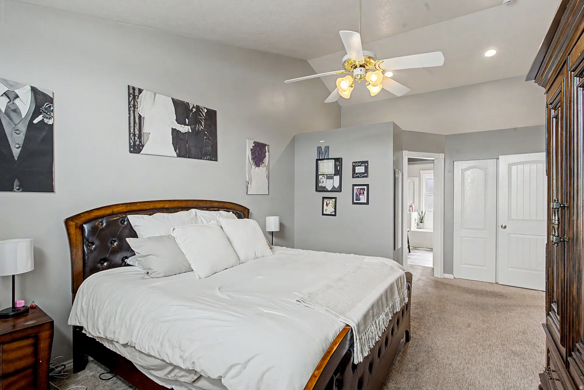 Bedroom featuring vaulted ceiling, light carpet, ceiling fan, recessed lighting, and connected bathroom