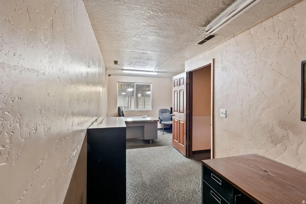 Office with a textured wall and a textured ceiling