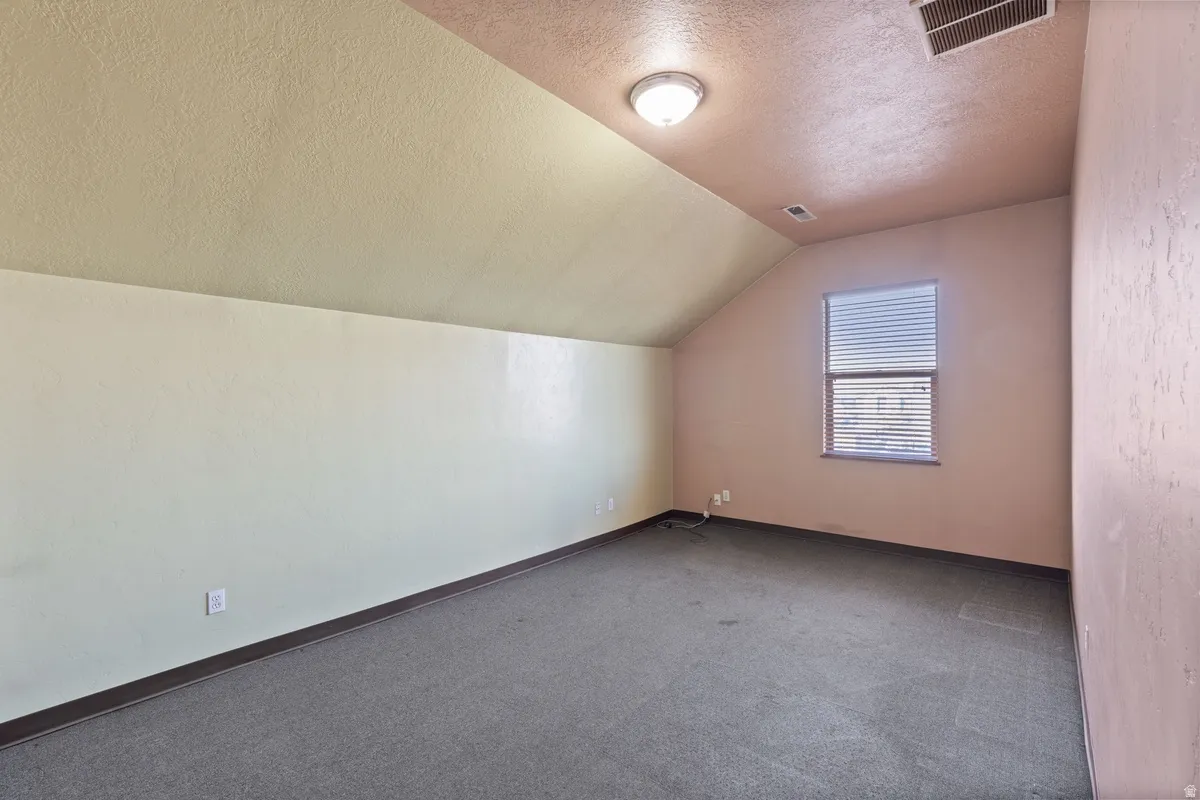 Bonus room with carpet flooring and baseboards