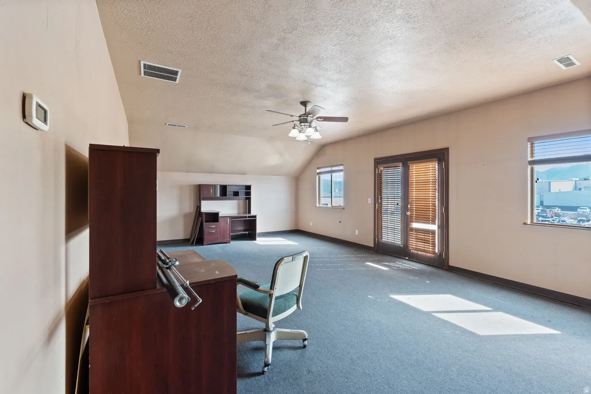 Carpeted office featuring baseboards and a ceiling fan