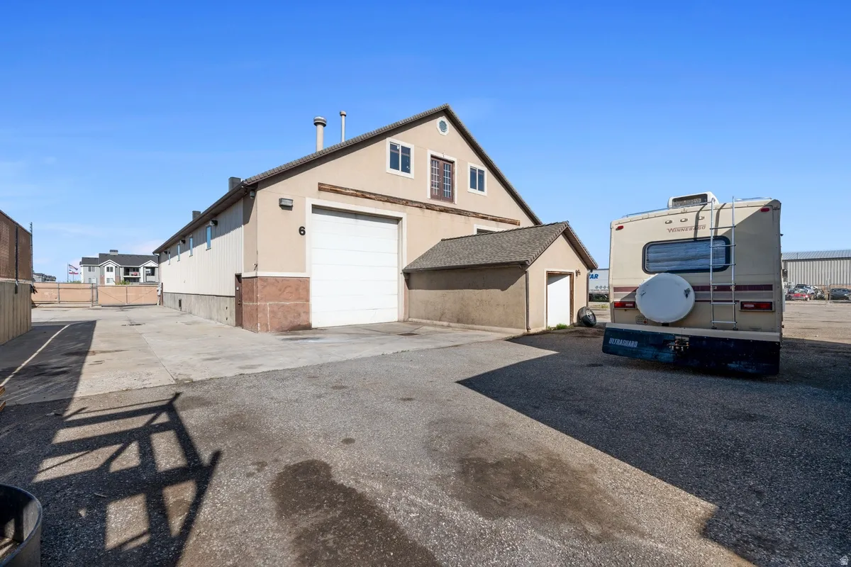 View of property exterior with a garage, an outbuilding, and driveway