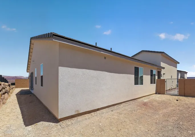 Modern residential construction featuring clean stucco exterior walls in neutral tones, metal roof edging, and contemporary architectural lines