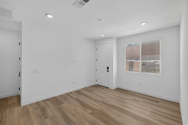Light wood-finish flooring with white baseboards throughout