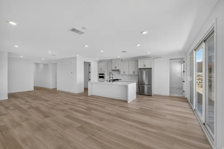 Spacious open-concept living area featuring wood-finish flooring and recessed lighting