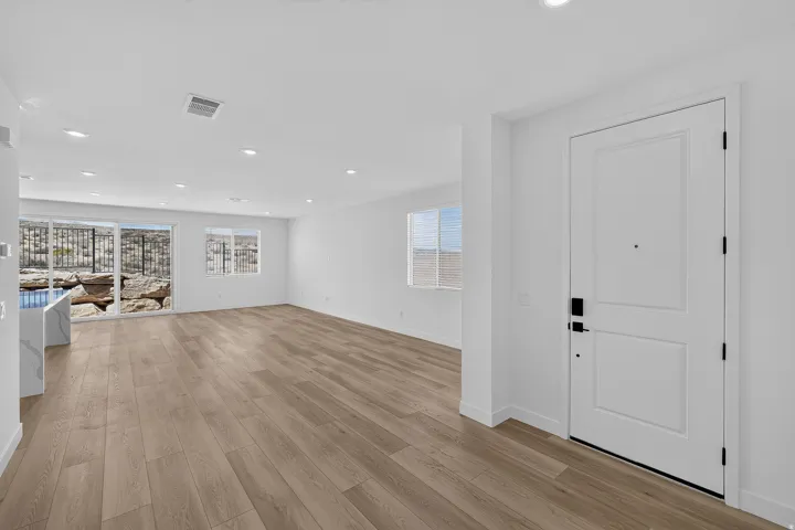 Spacious living area featuring wood-finish flooring, recessed lighting, and a neutral color palette