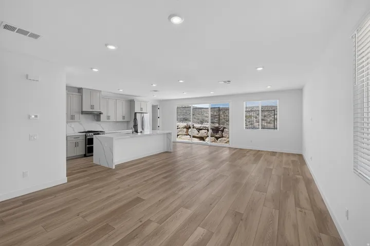 Open-concept living area featuring wood-finish flooring, recessed lighting, and a modern kitchen