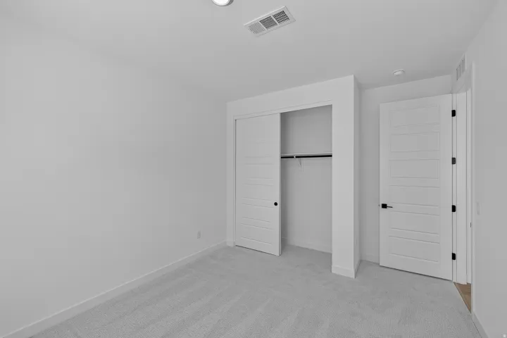 Neutral-toned room featuring light gray carpet flooring and white walls