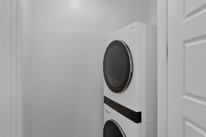 Dedicated laundry area featuring a stacked washer and dryer unit