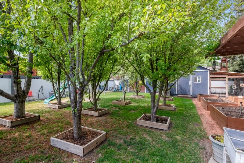 View of grassy yard featuring a garden and an outbuilding