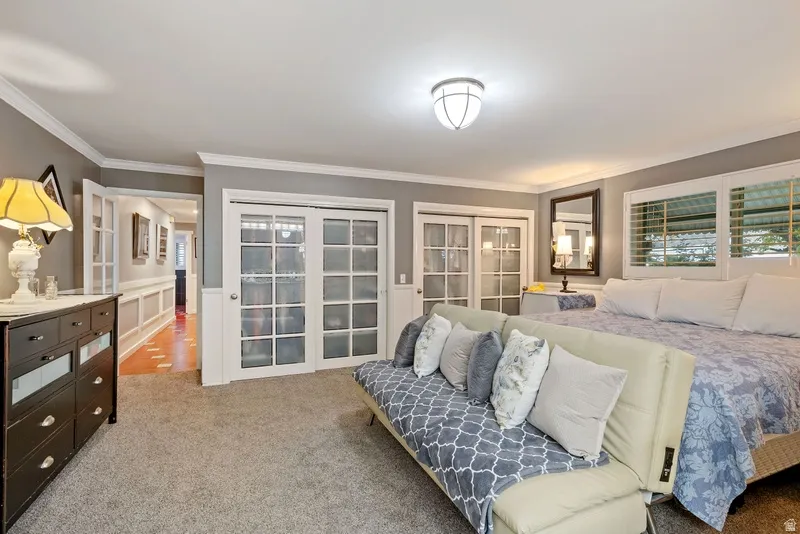 Bedroom featuring carpet, ornamental molding, french doors, and a closet