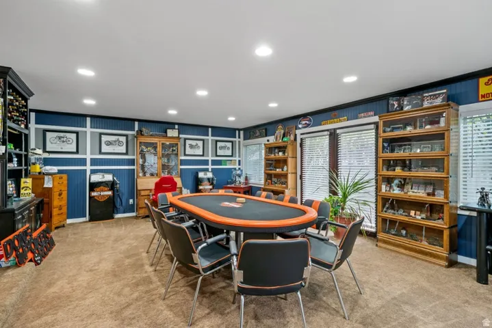 Recreation room with light carpet and recessed lighting