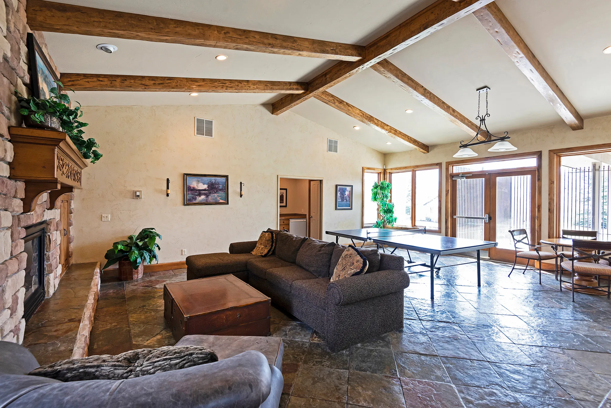 Living area featuring stone tile flooring, french doors, recessed lighting, and a fireplace