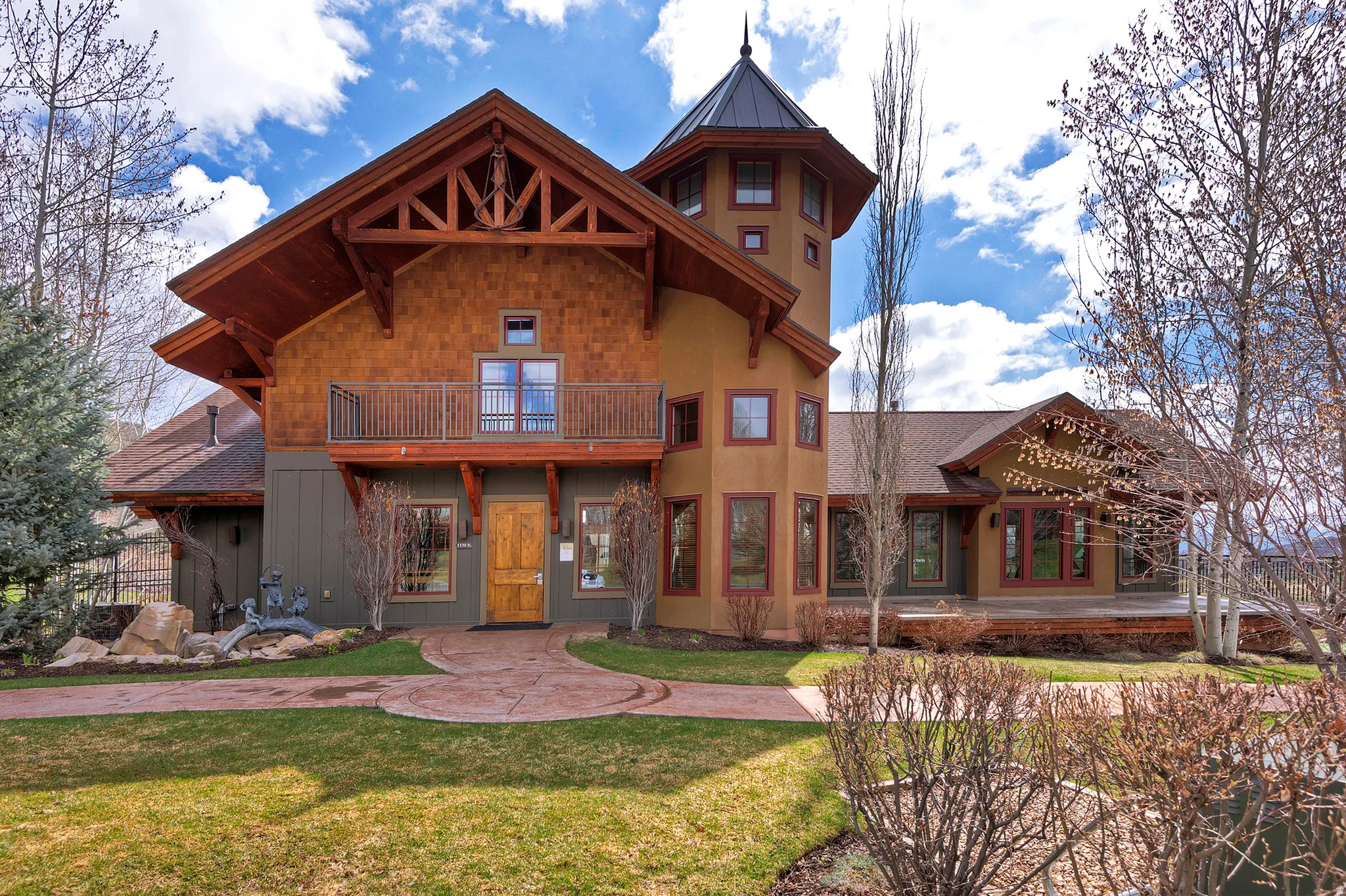 View of front of home with a balcony and a front yard