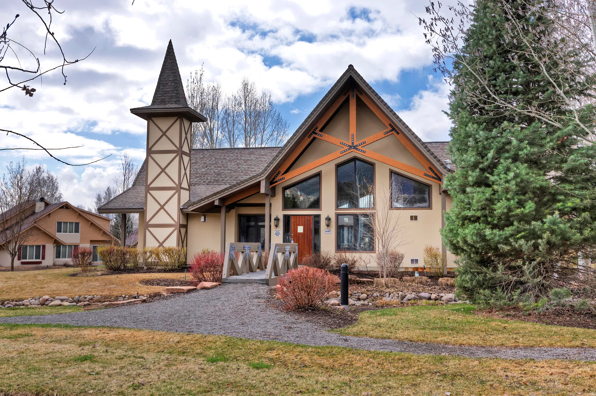 View of front of property featuring a front yard, stucco siding, and a shingled roof