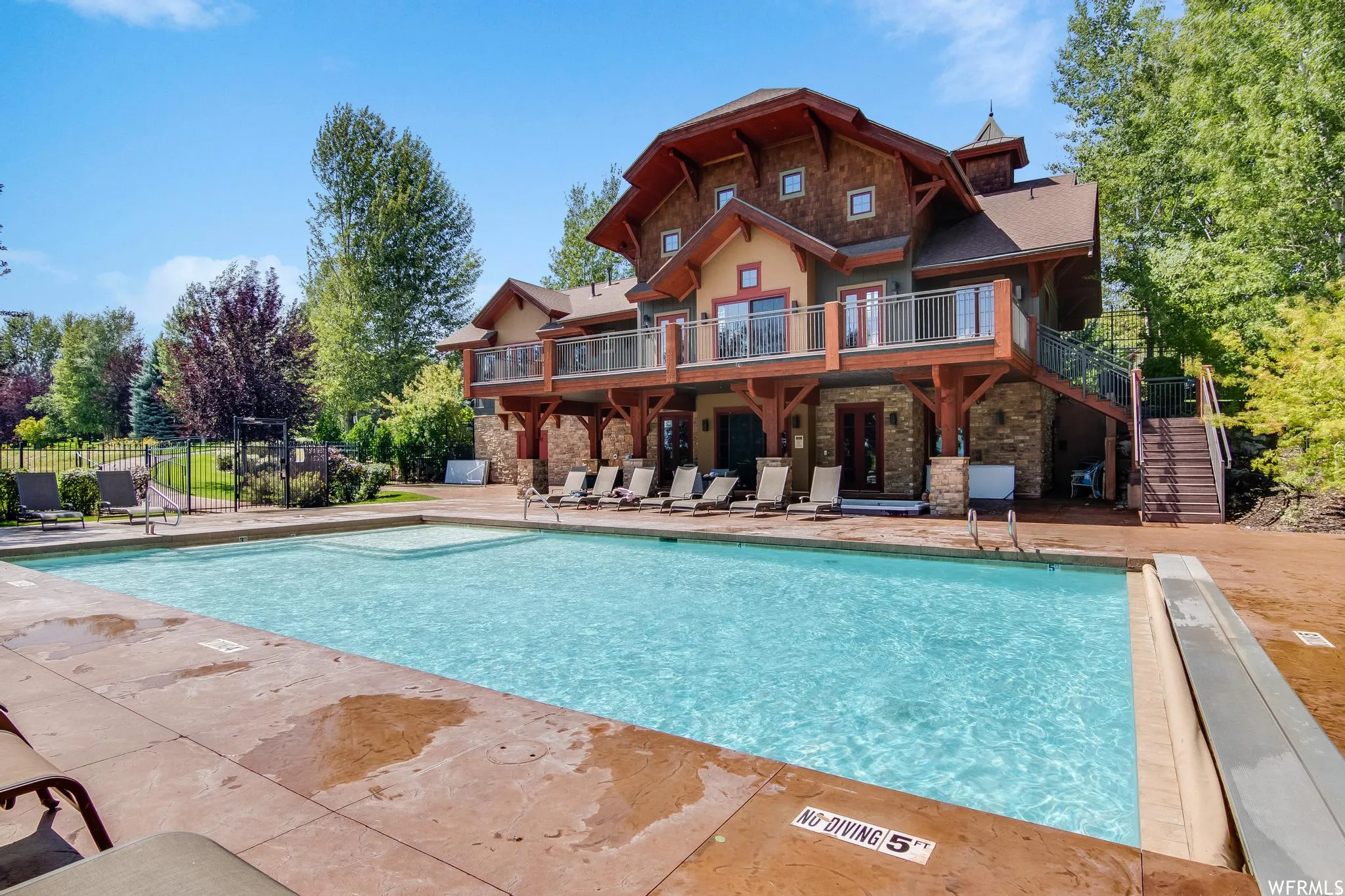 Community pool with a wooden deck and a patio area