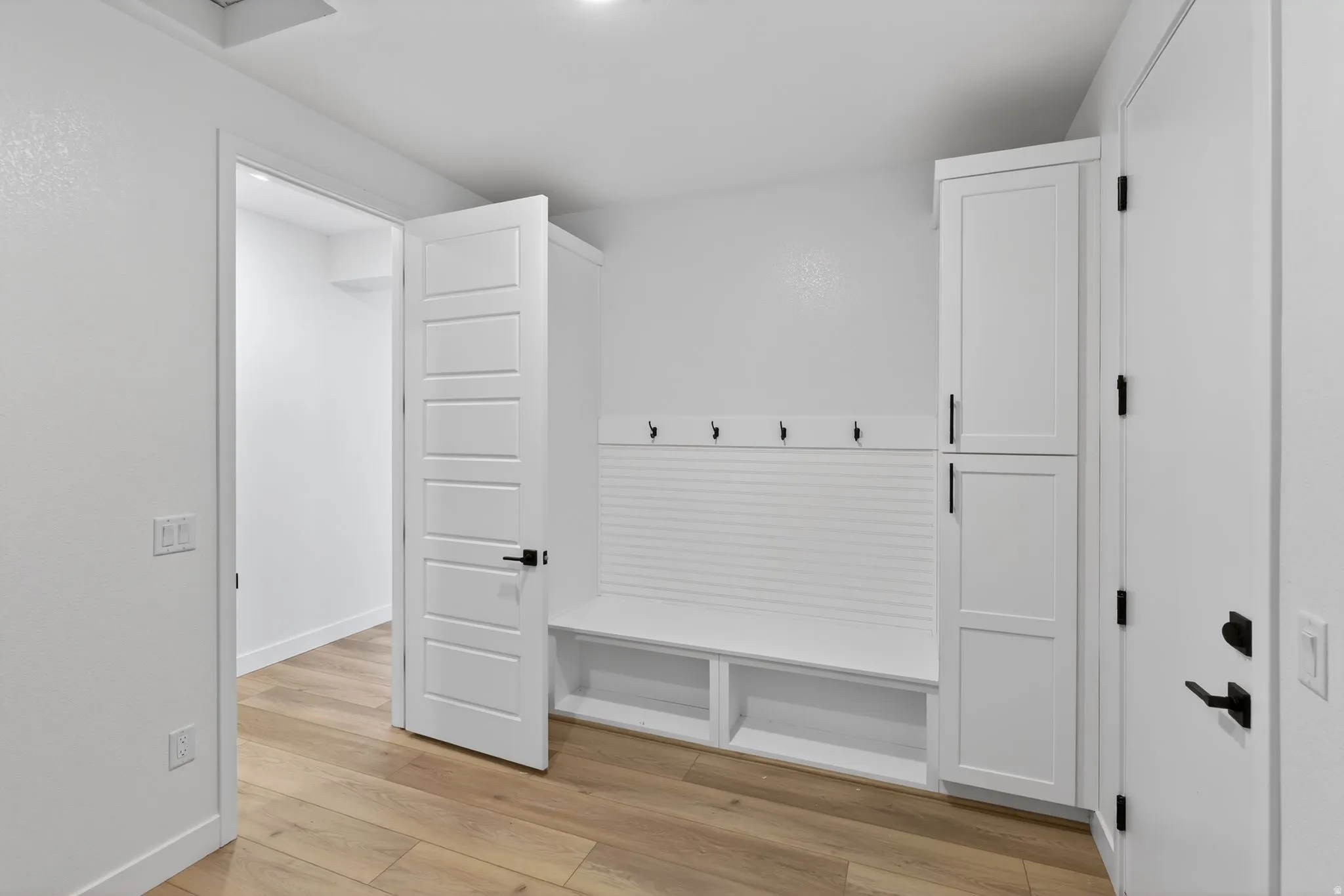 Mudroom with light wood-style floors and baseboards